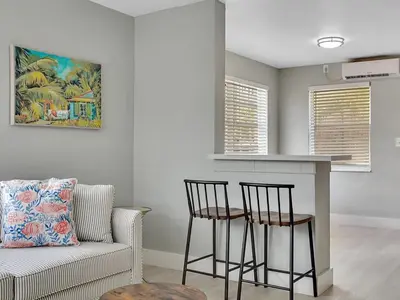 a living room with a bar and two chairs and a couch at Hollywood Beach 1BR Getaway | WiFi + AC in Dania Beach