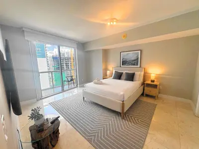 a bedroom with a bed and a large window at Luxury Miami Condo with Breathtaking City & Bay Views in Miami