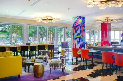 a lobby with colorful chairs and tables and a bar at Luxury Miami Condo with Breathtaking City & Bay Views in Miami