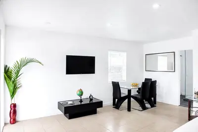 a living room with a table and chairs and a tv at Buena Vista-Miami Designer Studio # 1 in Miami