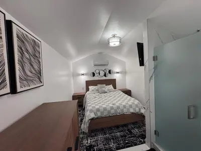 a white bedroom with a bed and a television at Hallandale Beach Club in Hallandale Beach