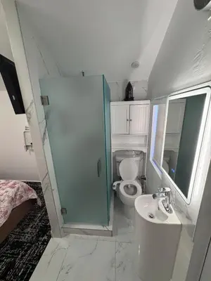 a small bathroom with a toilet and a sink at Hallandale Beach Club in Hallandale Beach