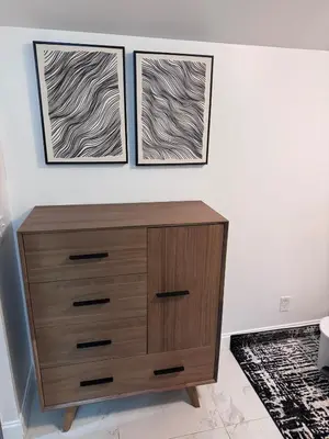 a dresser in a room with two pictures on the wall at Hallandale Beach Club in Hallandale Beach