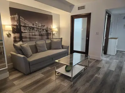 a living room with a couch and a glass table at Big studio with rooftop pool ocean view in Miami Beach