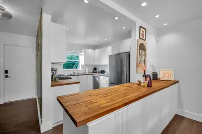 a kitchen with white cabinets and a wooden counter top at Vista Mar Scenic 3BR Family Waterfront w Private Dock in North Miami