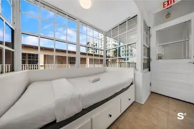 a large bed in a room with large windows at Spacious 1BD Beachside Apt with Free Parking in Miami Beach