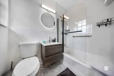 a white bathroom with a toilet and a sink at Spacious 1BD Beachside Apt with Free Parking in Miami Beach