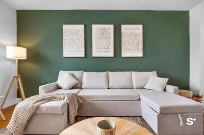 a living room with a couch and a green wall at Spacious 1BD Beachside Apt with Free Parking in Miami Beach