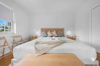 a white bedroom with a large bed and two chairs at Modern 1-BD Beachside Apt with Free Parking in Miami Beach