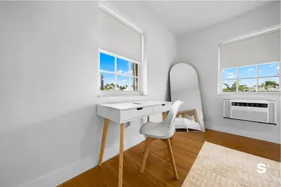 a white desk and chair in a room with windows at Modern 1-BD Beachside Apt with Free Parking in Miami Beach