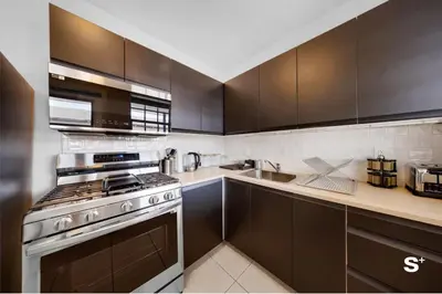 a kitchen with black cabinets and a stove top oven at Modern 1-BD Beachside Apt with Free Parking in Miami Beach