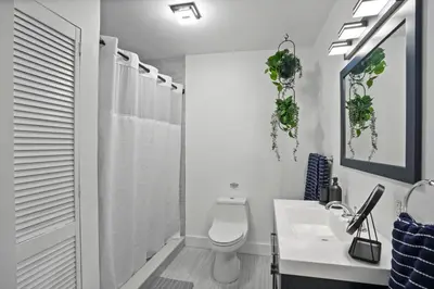 a white bathroom with a toilet and a sink at Luxury 1 bedroom apt in Kendall Prime Location in Westwood Lake
