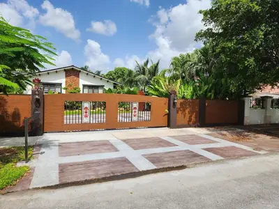 a wooden fence with a gate in front of a house at Sunset in Sunset