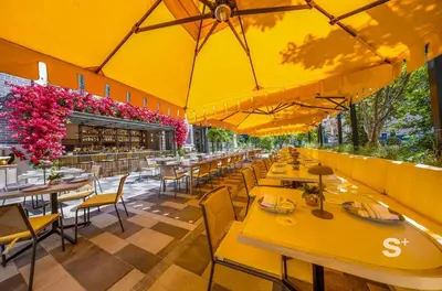 a restaurant with tables and chairs and yellow umbrellas at 1-BD Condo in DTW Miami - City Views in Miami