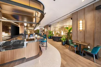 a bar in a hotel lobby with green chairs at Modern Downtown Studio with city views in Miami