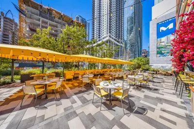 a patio with tables and chairs and yellow umbrellas at Modern Downtown Studio with city views in Miami
