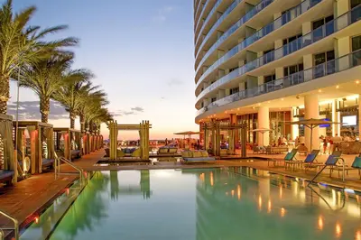 a hotel swimming pool with palm trees and a building at Penthouse Vacation Beach Resort in Hollywood