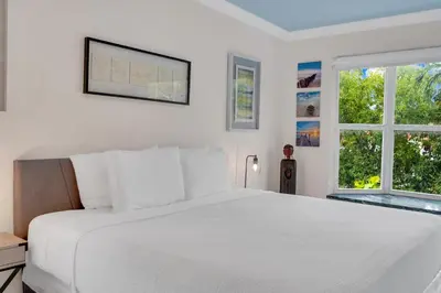 a white bedroom with a large bed and two windows at Magnificent Tropical Pool Home Miami SouthBrickell in Miami
