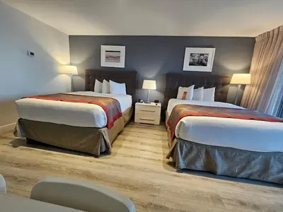 a hotel room with two beds and a table and chairs at Ocean front paradise studio with ocean view and beach exit in Sunny Isles Beach