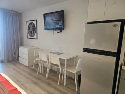 a kitchen with a white table and a refrigerator at Ocean front paradise studio with ocean view and beach exit in Sunny Isles Beach