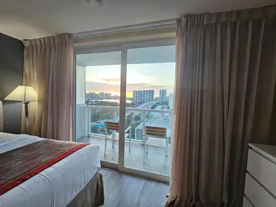 a hotel room with a bed and a large window at Beach Studio with City View in Sunny Isles Beach