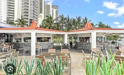 an outdoor restaurant with tables and chairs and buildings at Beach Studio with City View in Sunny Isles Beach