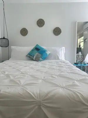 a white bed with two hearts on the wall at 2 Nice and Cozy guest house in Opa-locka