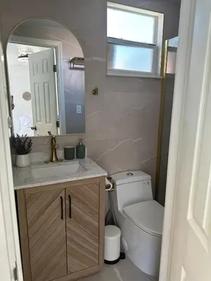 a bathroom with a toilet and a sink and a mirror at 2 Nice and Cozy guest house in Opa-locka