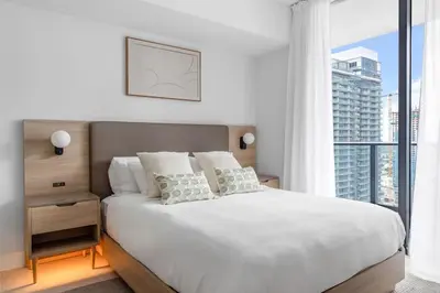 a bedroom with a white bed with a large window at 3701 Kaseya Center 2 Bdr Apt with Pool and Gym in Miami