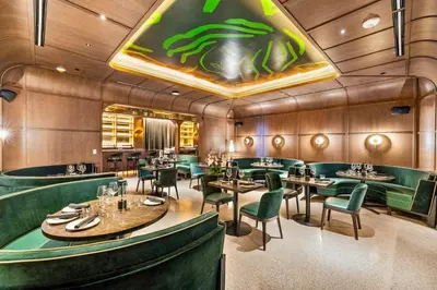 a dining room with green chairs and tables at 3005 golden305 2BR Apt mins to Wynwood and Brickell w Pool a Gym and PS5 in Miami
