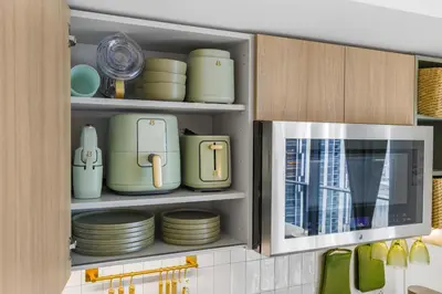 a kitchen cabinet filled with plates and dishes at 3005 golden305 2BR Apt mins to Wynwood and Brickell w Pool a Gym and PS5 in Miami