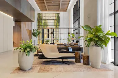 a living room with plants in large white vases at 3610 Calm Blue Studio w Balcony View Pool and Gym in Miami