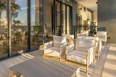 a patio with white chairs and a table on a balcony at 3610 Calm Blue Studio w Balcony View Pool and Gym in Miami