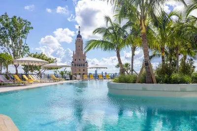 a hotel swimming pool with a clock tower in the background at 3610 Calm Blue Studio w Balcony View Pool and Gym in Miami