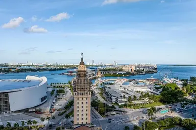 a clock tower in a city next to the water at 4305 High Floor Apt with City and Marina Views in Miami