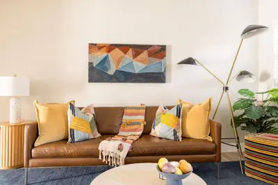 a living room with a brown couch with pillows at Wynwood beautiful Art Deco home with 4 Bedroom in Miami