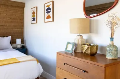 a bedroom with a bed and a wooden dresser with a mirror at Wynwood beautiful Art Deco home with 4 Bedroom in Miami