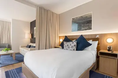 a hotel room with a large bed and a couch at 2012 New Apt with Pool and Gym in front of Kaseya Center in Miami
