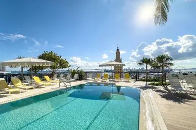 a pool with chairs and a clock tower in the background at 3013 Kaseya Center Apt for 4 people with Pool and Gym in Miami