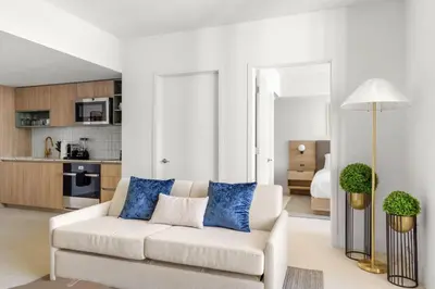 a living room with a white couch and blue pillows at 2409 Apt in Downtown Miami with Gym and in front of Kaseya Center in Miami