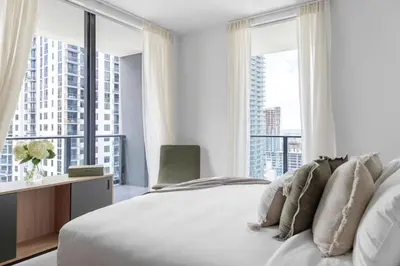 a bedroom with a white bed and large windows at 3002 Downtown Miami apt in front of Kaseya Center with Gym and Pool in Miami