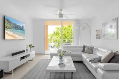 a white living room with a white couch and a table at Aventura Mall Apt with Pool a Tennis Court and Free parking in Aventura