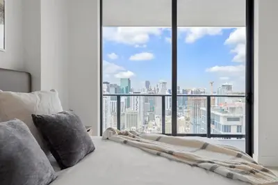 a bed in a room with a large window at 3808 Apt Next to Kaseya Center with Pool a Spa and Gym in Miami