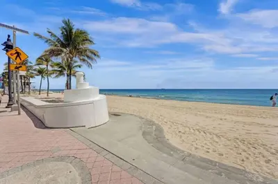 a sandy beach with palm trees and the ocean at Eden Collection Junior Suite Steps to Beach in Fort Lauderdale