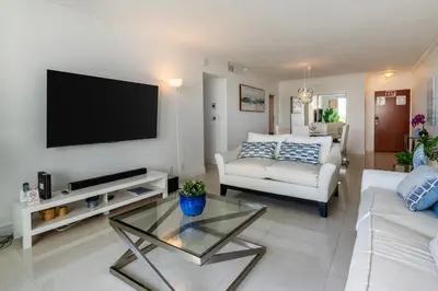 a living room with a couch and a tv on a wall at Beachfront Winter Escape, Balcony with Ocean View, Amenities in Hollywood