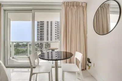 a dining room with a table and chairs and a window at Sunny Isles Beach Ocean View Studio with Balcony in Sunny Isles Beach