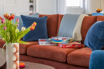 a couch with books and popcorn and a vase with flowers at Tropical Retreat on Sheridan l Near Beach and Parks in Hollywood