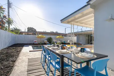 a black table with blue chairs on a patio at Tropical Retreat on Sheridan l Near Beach and Parks in Hollywood