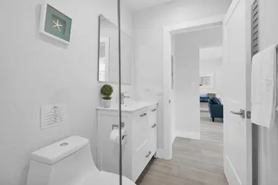 a white bathroom with a toilet and a glass shower at Palm Haven in Fort Lauderdale