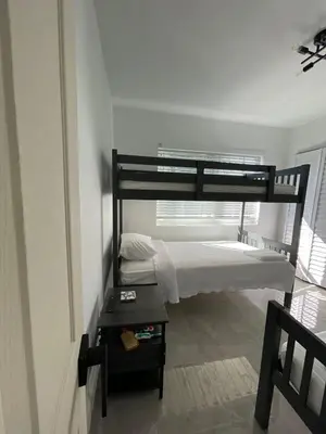 a bedroom with two bunk beds and a table at USA Star Hostel in Hallandale Beach